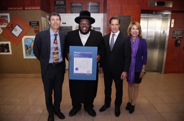 Nissim Black, songwriter, record producer and rapper, accepts a proclamation at a Miami-Dade School Board meet